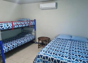 a bedroom with two bunk beds and a stool at Corrales House in Tela