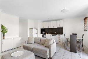 a living room with a couch and a table at 1 Bedroom Ground Level Unit in Noosaville Resort in Noosaville
