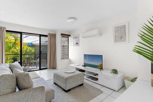 a living room with a couch and a tv at 1 Bedroom Ground Level Unit in Noosaville Resort in Noosaville