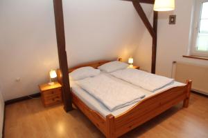 een slaapkamer met een houten bed met 2 nachtkastjes bij Uttumer Mühle Eiske in Krummhörn