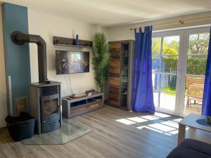 a living room with a fireplace and a tv at Seehund Feriendoppelhaus "Schäferhund" in Thiessow