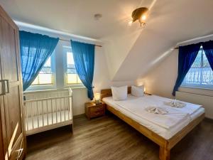 a bedroom with a bed with blue curtains at Seehund Feriendoppelhaus "Schäferhund" in Thiessow