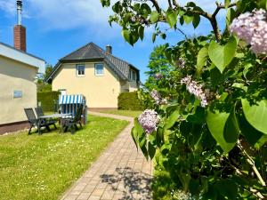 a garden with a bench and a house at Seehund Feriendoppelhaus "Schäferhund" in Thiessow