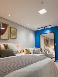 1 dormitorio con 1 cama grande y espejo en Loft luxuoso na Serra - Granja Brasil Resort itaipava - Petrópolis en Petrópolis