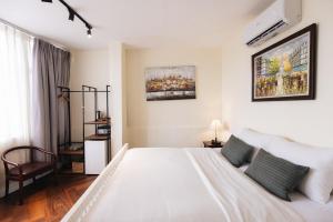 9 Hostel and Suites في مدينة هوشي منه: غرفة نوم بيضاء بسرير وكرسي