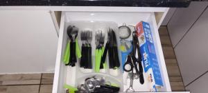 un tiroir rempli d'ustensiles de cuisine dans une armoire dans l'établissement Chácara paraíso, à Socorro