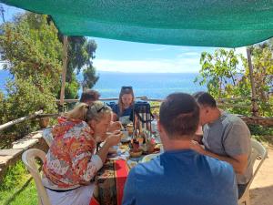 Ocosuyo的住宿－kawsay Wasi Lodge De Oswaldo Cari，一群坐在餐桌旁吃饭的人