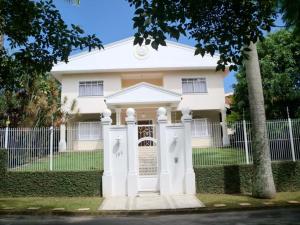 a white house with a sign in front of it at Pousada - Flat - Kitnet - Mobiliada, Confortável e Perto de Tudo in Atibaia
