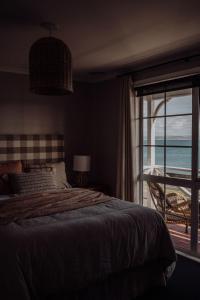 a bedroom with a bed and a view of the ocean at Little Talisker in Stanley