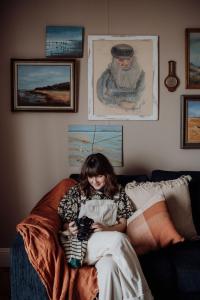 a woman sitting on a couch holding a camera at Little Talisker in Stanley