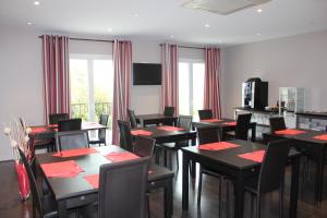 un comedor con mesas y sillas con servilletas rojas en Hôtel Le Domaine des Vignes Ampuis Lyon Sud Vienne en Ampuis