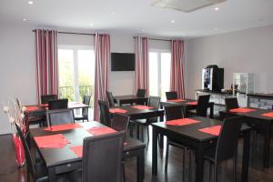 a dining room with tables and chairs with red napkins at Hôtel Le Domaine des Vignes Ampuis Lyon Sud Vienne in Ampuis