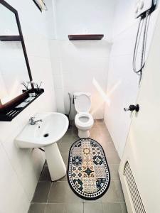 a bathroom with a white toilet and a sink at Vangvieng Pool House Hotel in Vang Vieng