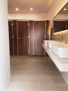 baño con 2 lavabos y armarios de madera en 9 Hostel and Suites en Ho Chi Minh