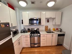 uma cozinha com armários brancos e um fogão de aço inoxidável em Studio room em Nova York