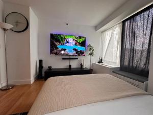 um quarto com uma cama e uma televisão de ecrã plano na parede em Studio room em Nova York