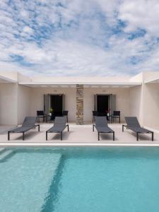 a patio with chairs and a swimming pool at Amouage Studios in Kampos Paros