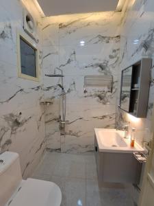 a white bathroom with a sink and a toilet at نسيم العوالي in Ash Shishah