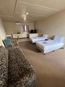 Opal Inn Hotel, Motel, Caravan Park في كوبر بيدي: غرفة بها كنبتين وطاولة وكراسي