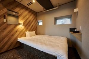 Postel nebo postele na pokoji v ubytování CAPSULE HOTEL CONTINUE NijojoKita