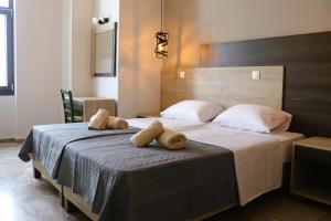 a bedroom with a large bed with two pillows on it at The Stonehouse at the Harbor in Pythagoreio