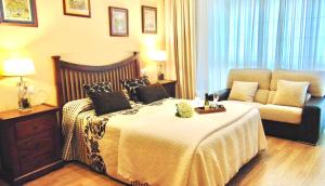 a hotel room with a bed and a couch at Casa centro o grove con terraza y asador in O Grove
