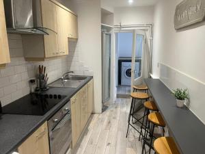 a kitchen with a sink and a counter with stools at Harrington Apartments in Central London in London