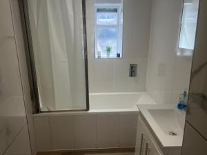 a white bathroom with a shower and a sink at Harrington Apartments in Central London in London