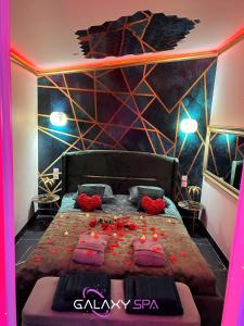 a bedroom with a large bed with red pillows at GALAXY SPA - Suite Jupiter Jacuzzi Privatif in Champigneulles +20 photos