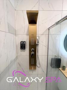 La salle de bains est pourvue d'une douche et d'un téléphone mural. dans l'établissement GALAXY SPA - Suite Jupiter Jacuzzi Privatif, à Champigneulles