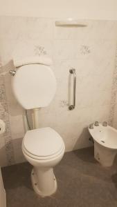 uma casa de banho com um WC branco e um lavatório. em Hotel Azul Junin em Junín