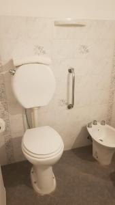 ein Badezimmer mit weißer Toilette und Waschbecken in der Unterkunft Hotel Azul Junin in Junín + 54 Fotos
