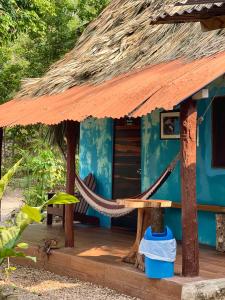 a blue house with a hammock in front of it at Hotel Mon Ami in El Remate