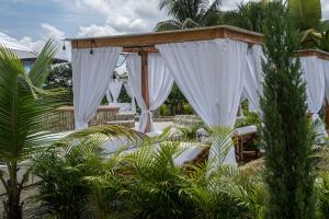 een buitenaltaar met witte gordijnen in een tuin bij FINCA HOTEL LA QUINTA DE TORRIONE in Quimbaya