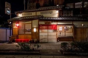 un edificio con un banco rojo delante de él en ホステル祇園SORA, en Kioto