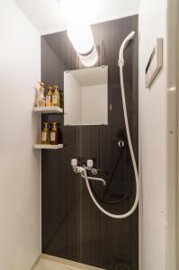 een badkamer met een douche met een douchekop bij ホステル祇園SORA in Kyoto