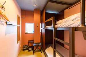 Mały pokój z łóżkiem piętrowym i krzesłem w obiekcie ホステル祇園SORA w mieście Kioto