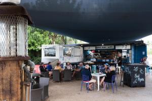 a group of people sitting at a table in front of a food truck at Tasman Holiday Parks - Rollingstone in Rollingstone