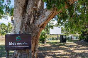 a kids movie sign in front of a tree at Tasman Holiday Parks - Rollingstone in Rollingstone