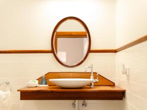 een badkamer met een wastafel en een spiegel bij Maddies of Bolwarra in Maitland