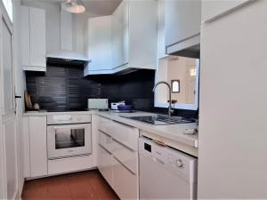 滨海巴纽尔斯Villa méditerranéenne, vue mer, accès crique, Banyuls-sur-Mer - FR-1-309-293的带白色橱柜和水槽的白色厨房