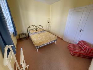 ein Schlafzimmer mit einem Bett und einem roten Stuhl in der Unterkunft Maison lumineuse avec jardin près de la plage - 4 couchages, quartier calme, St Brévin L'Océan - FR-1-364-136 in Saint-Brevin-les-Pins