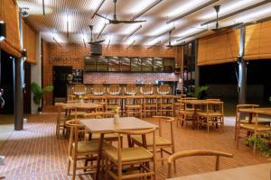 un ristorante con tavoli e sedie in una stanza di Vanavasa Resort a Bentong