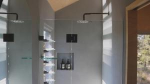 una doccia in vetro in un bagno con bottiglie di vino di Hunter Valley Vineyard Cabin by Outpost a Pokolbin