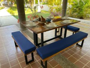 a wooden table with blue seats and a table and chairs at Casa Amin Tolu in San Silvestre