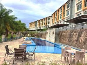 a group of chairs and tables in front of a building at Apt Alto da Serra Villas - Bananeiras in Bananeiras