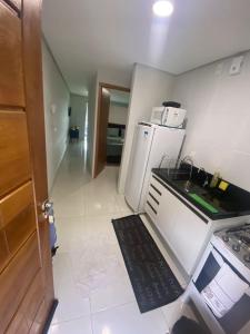 a small kitchen with a stove and a refrigerator at Apt Alto da Serra Villas - Bananeiras in Bananeiras