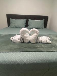 a bed with two towels in the shape of a heart at Apt Alto da Serra Villas - Bananeiras in Bananeiras +18 photos