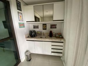 a small kitchen with a sink and a mirror at Apt Alto da Serra Villas - Bananeiras in Bananeiras