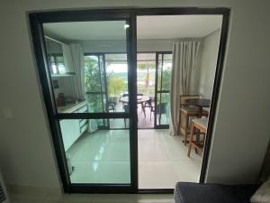 a glass door leading into a living room with a table at Apt Alto da Serra Villas - Bananeiras in Bananeiras